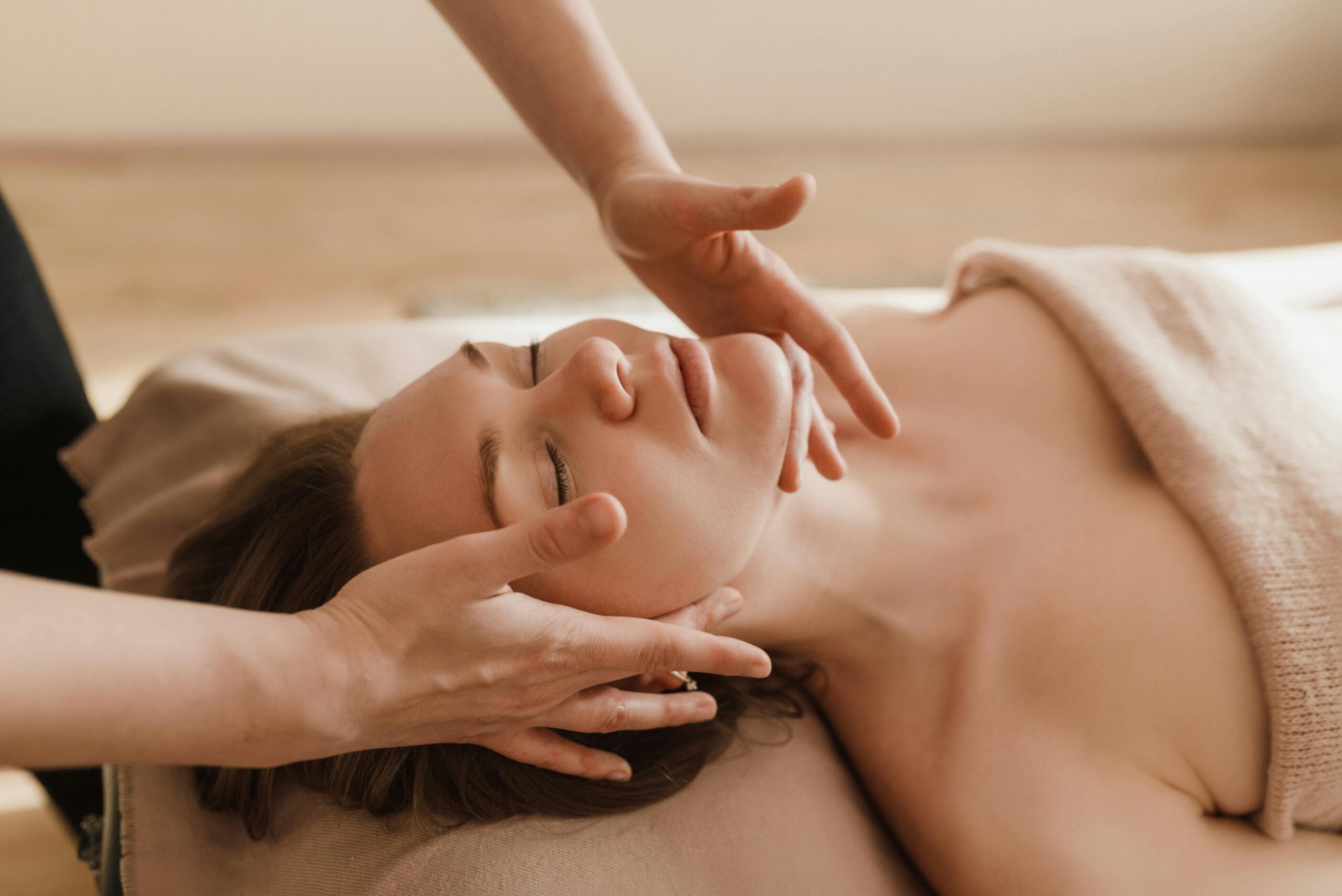 Woman receiving a soothing facial massage, promoting relaxation and wellness.